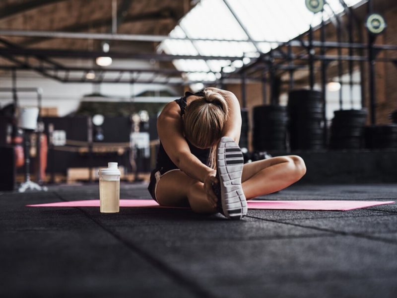 fit-young-woman-doing-stretches-on-a-gym-floor-QVWG8LX-min.jpg